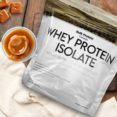 Bulk Protein Canada Butterscotch whey protein isolate on a table with butterscotch pieces