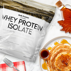 Bulk Protein Canada maple syrup whey protein isolate on a table with a plate of pancake